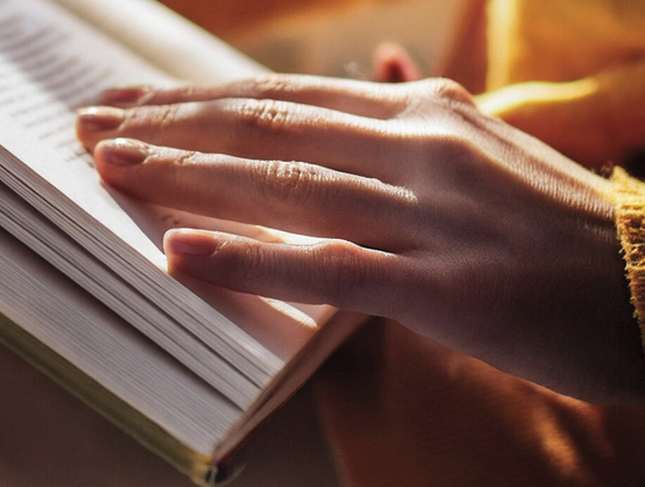 Symbolbild für Buch oder Bücher, weibliche Hand auf einem Buch